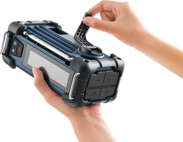 Een hand houdt een blauw Blackout-radio met een afneembare antenne.