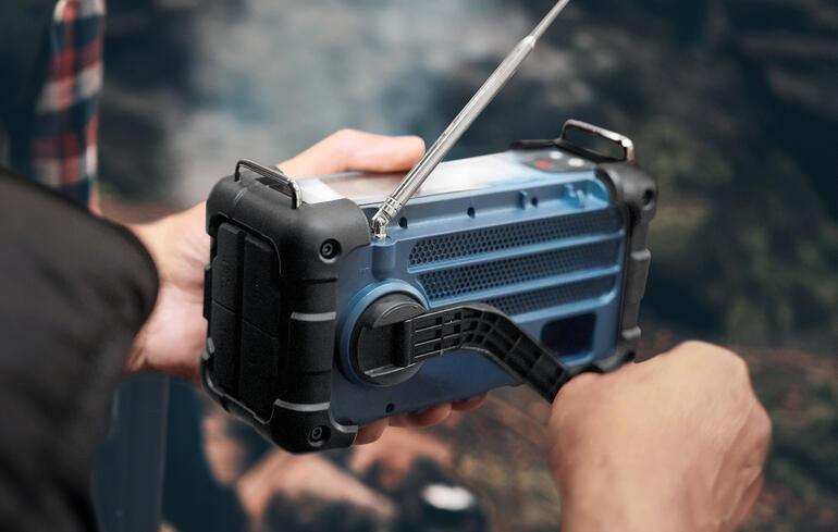 Man met de radio in de hand, gebruikt de antenne.