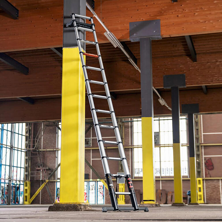 Telescoopladder tegen een muur in een magazijn.