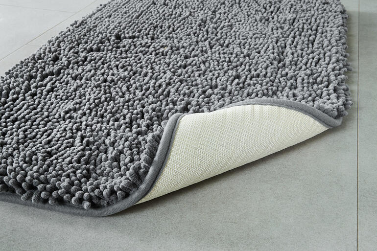 Vocht en vuil verzamelen zich in de 2,5 cm hoge pool van de antislipmat. Detailopname van de structuur van de huisdier-vuilmat.