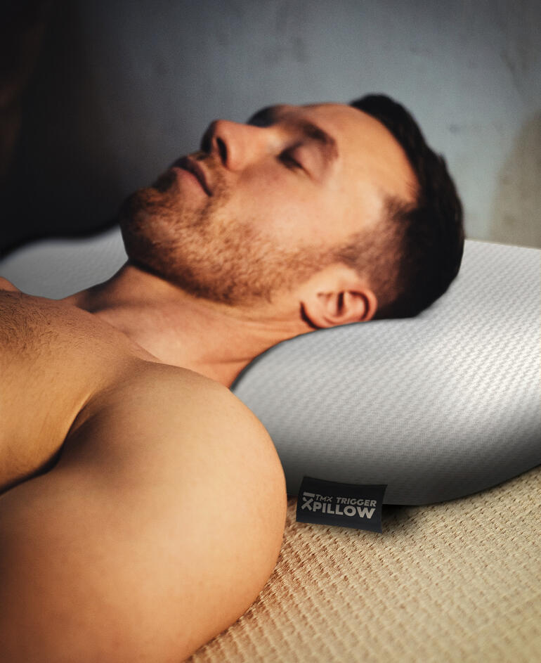 Man ligt ontspannen met zijn hoofd op een koelend Trigger-kussen.