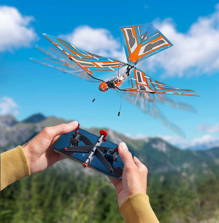 Afstandsbediend model van een vliegend insect met een oranje vleugelstructuur.