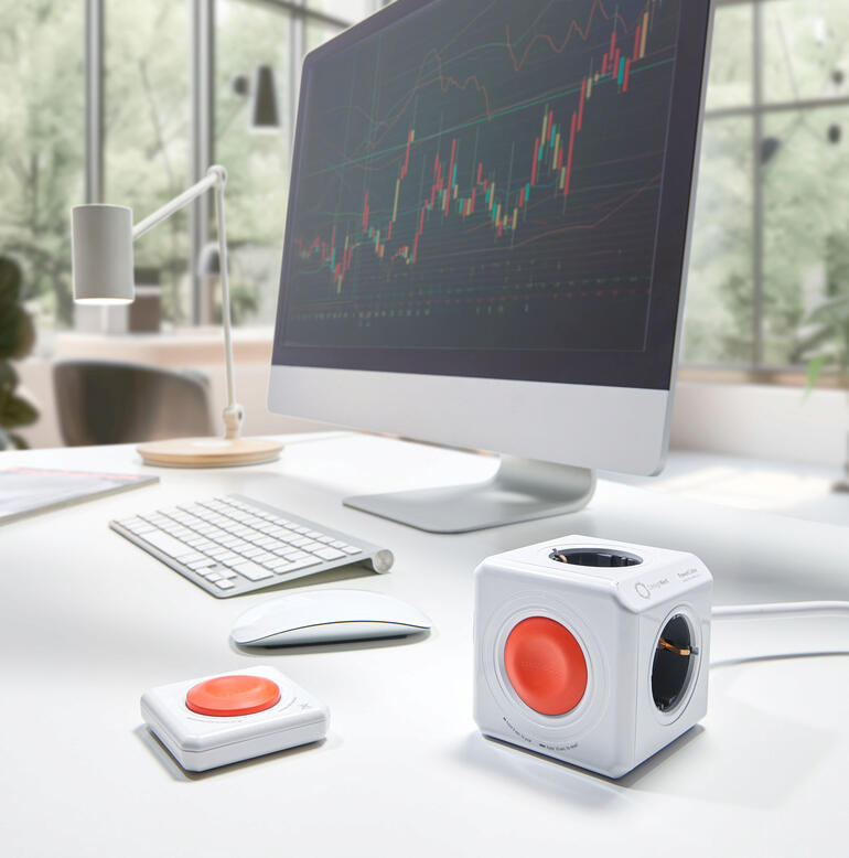 PowerCube Remote Set op een bureau met een computer en accessoires.
