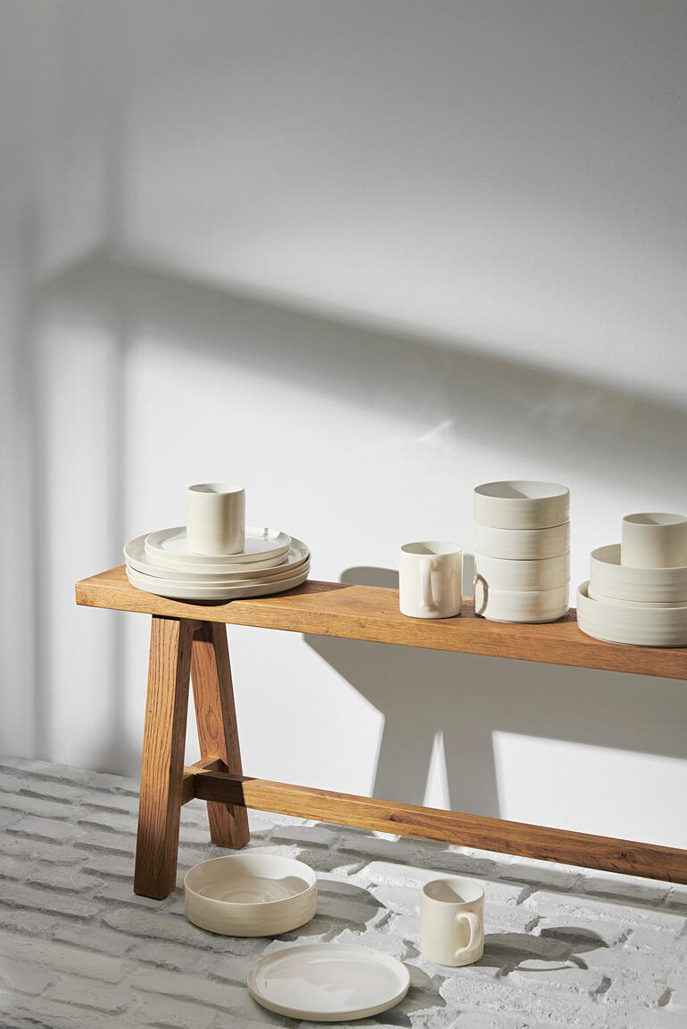 Reglaze Essteller 6-delige set decoratief gestapeld op een houten tafel.