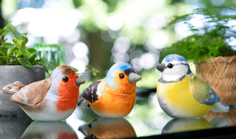 Drie decoratieve vogelfiguren in natuurlijke kleuren.