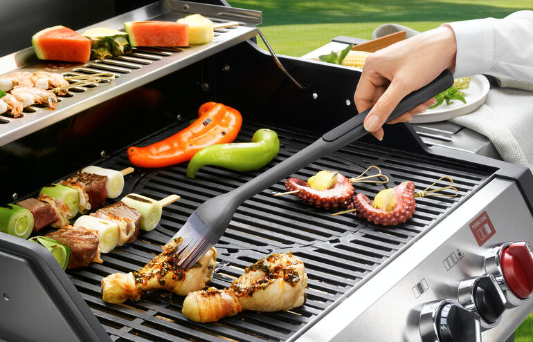 Grillkwast in actie om vlees op de grill aan te brengen.