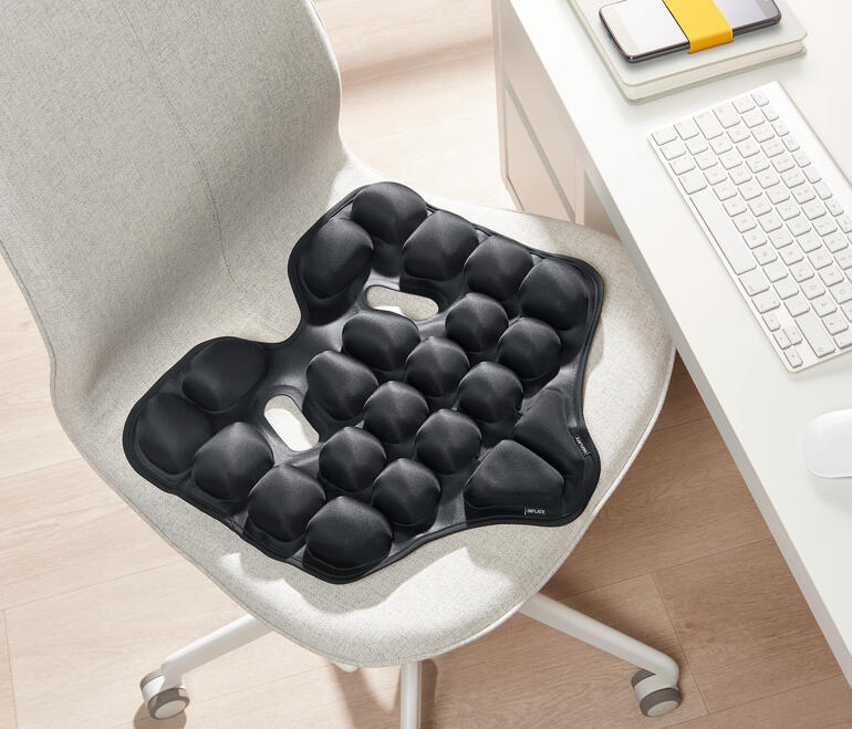 Zwart ergonomisch zitkussen op een stoel.
