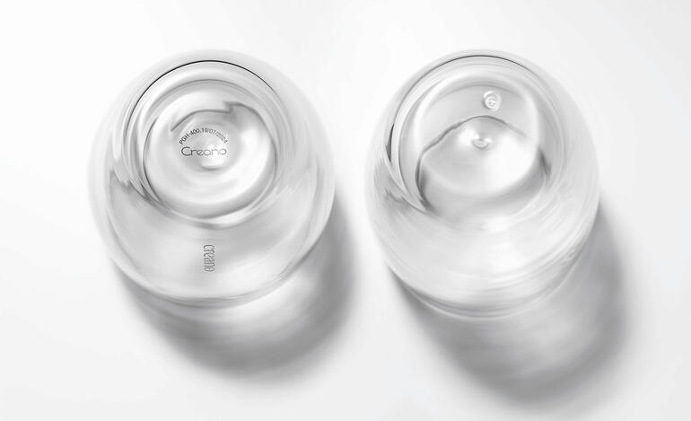 Mondgeblazen en hermetisch dicht – zonder de gebruikelijke blaasopening in de bodem. Twee heldere premium thermobekers met markante rondingen, zichtbaar op een witte achtergrond.