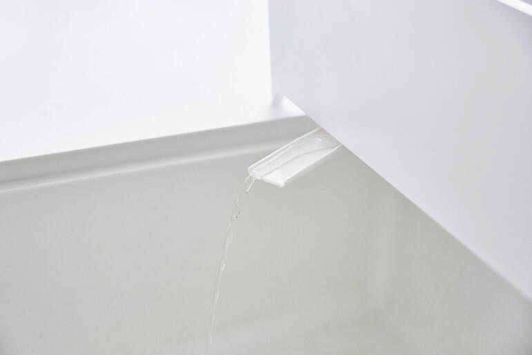 Close-up van de afvoerbak met waterafvoer.