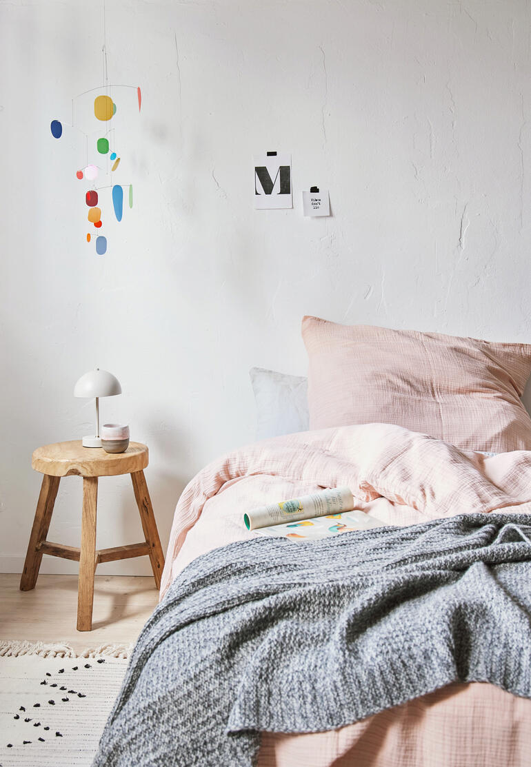 Toekomstige mobiel hangt boven een bed in een slaapkamer