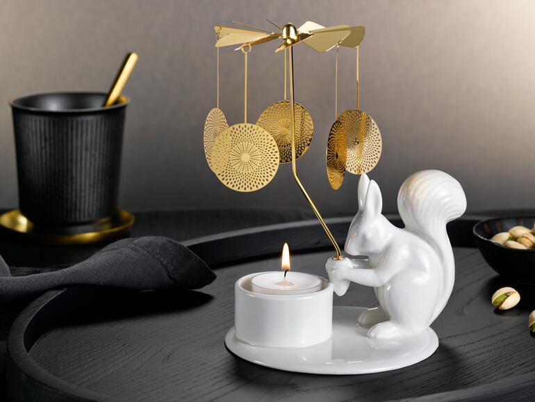 Theelichtcarrousel met een eekhoorn die een theelicht op een elegante tafel vasthoudt.