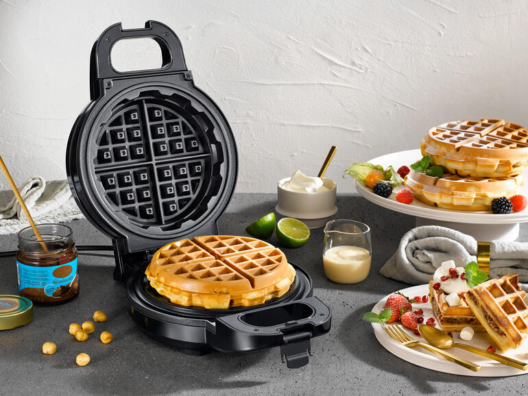 Extra diep wafelijzer met verse wafels en ingrediënten op een tafel.