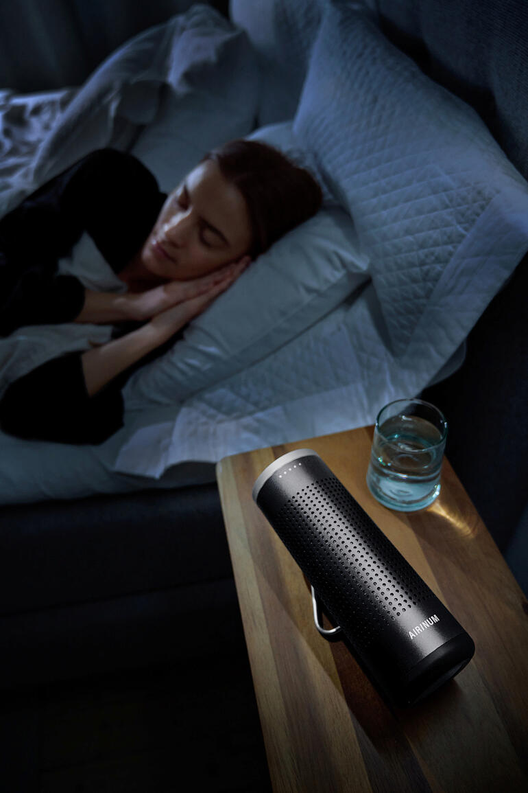 Mobiele 2-in-1 luchtreiniger op een nachtkastje naast een slapende persoon