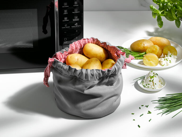 Grijze aardappelgarbeutel met aardappelen en kruiden op de tafel.