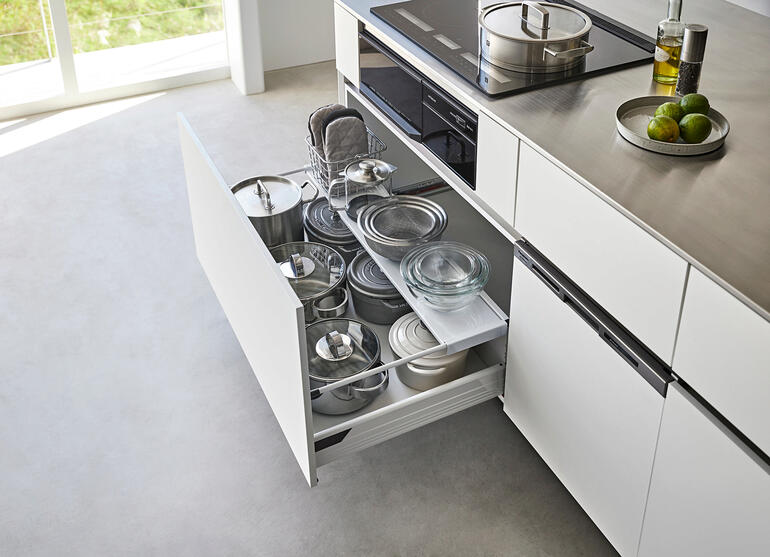 Zwarte lade-inzet met potten in een geopende keukenlade