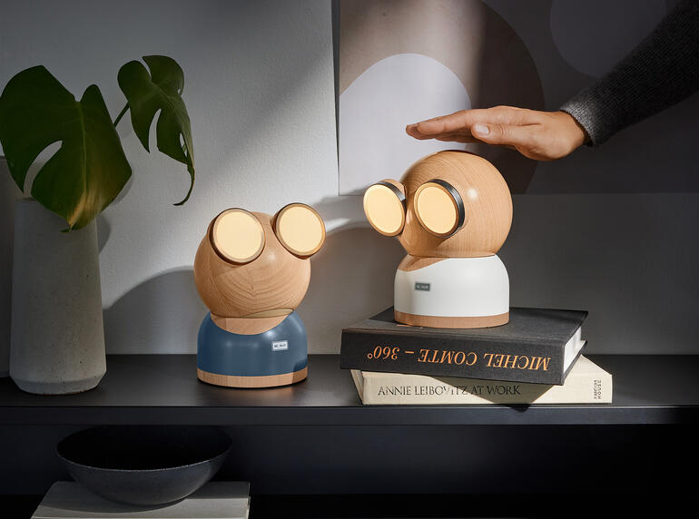 Twee Mr. Watt designlampen op een tafel met een boek.