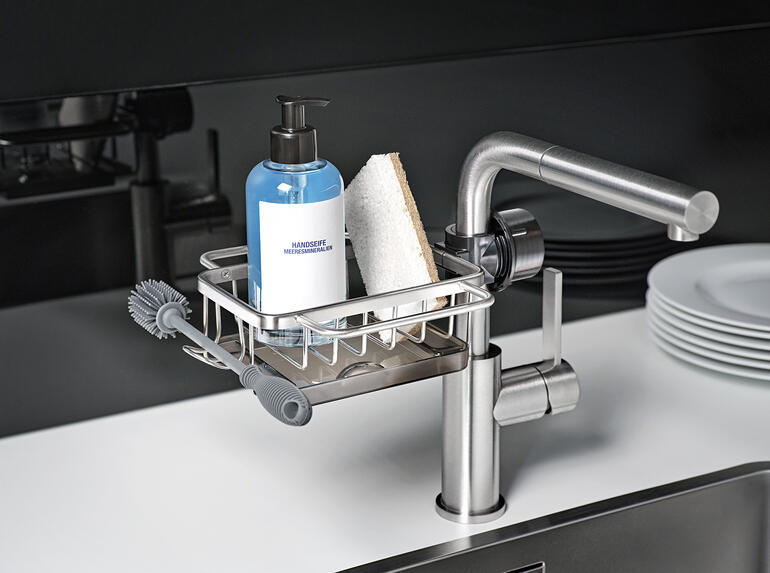 Spoelbak-organizer met fles en spons op de gootsteen.