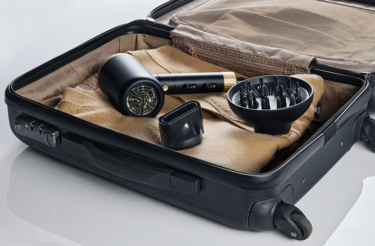 Compacte reisblowdryer in een koffer, inclusief accessoires.