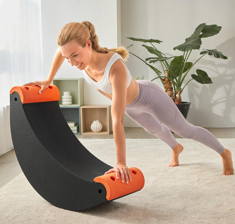 Vrouw traint op een 3-in-1 multifunctionele trainer met oranje handgrepen.