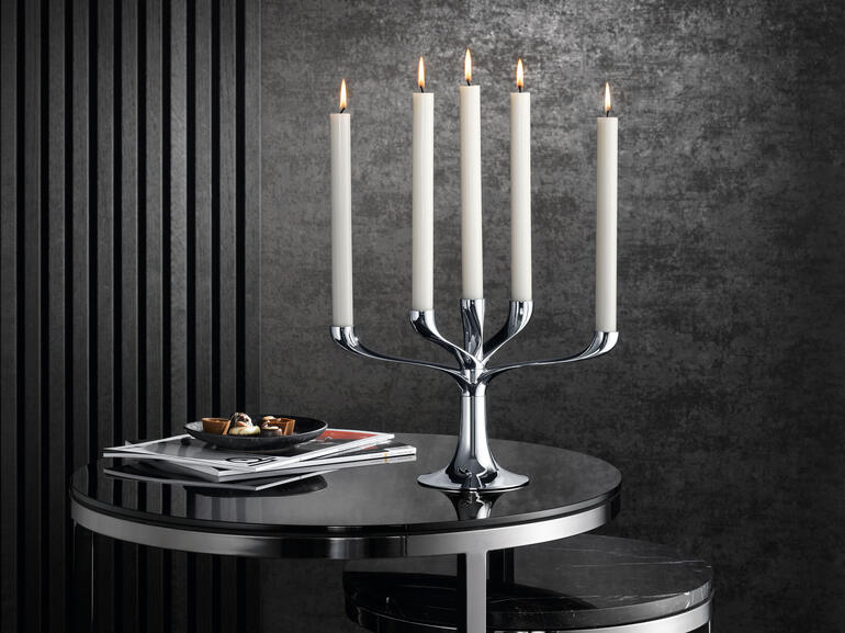 Moderne kandelaar met vijf kaarsen op een tafel, elegante decoratie.