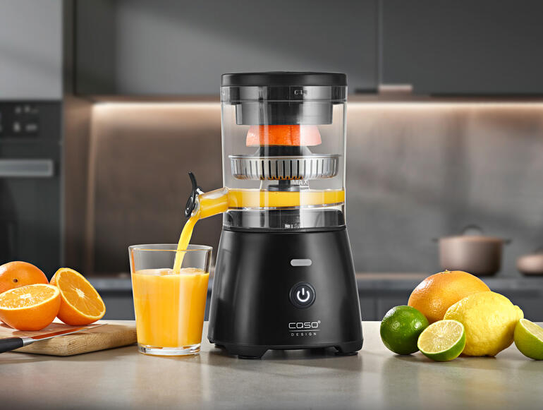 Volautomatische citruspers in de keuken, sinaasappel wordt geperst.