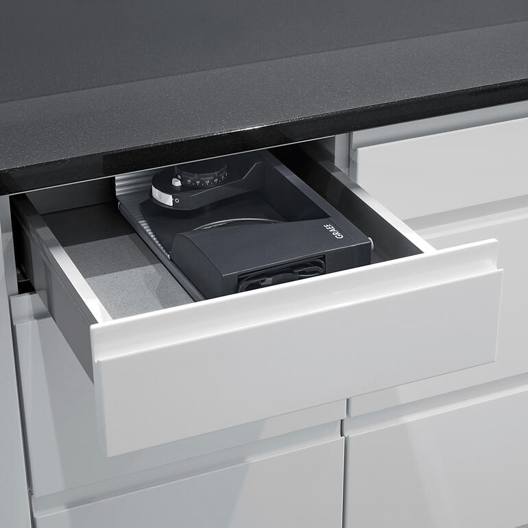 Met een breedte van slechts 8 cm past de ultracompacte allessnijder zelfs in een keukenlade. Ultracompacte snijmachine ligt in een lade.