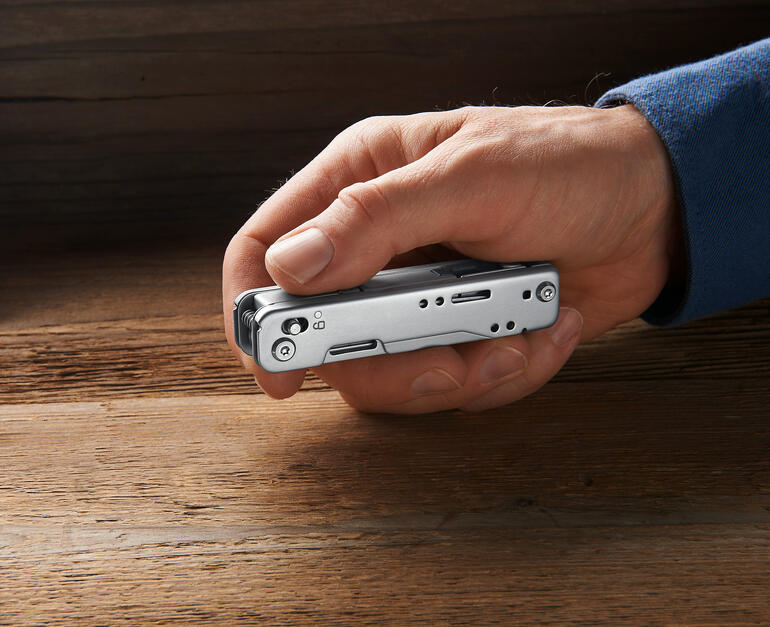 12-in-1 multitool Hand die een compact multitool 12-in-1 vasthoudt met gesloten gereedschappen.