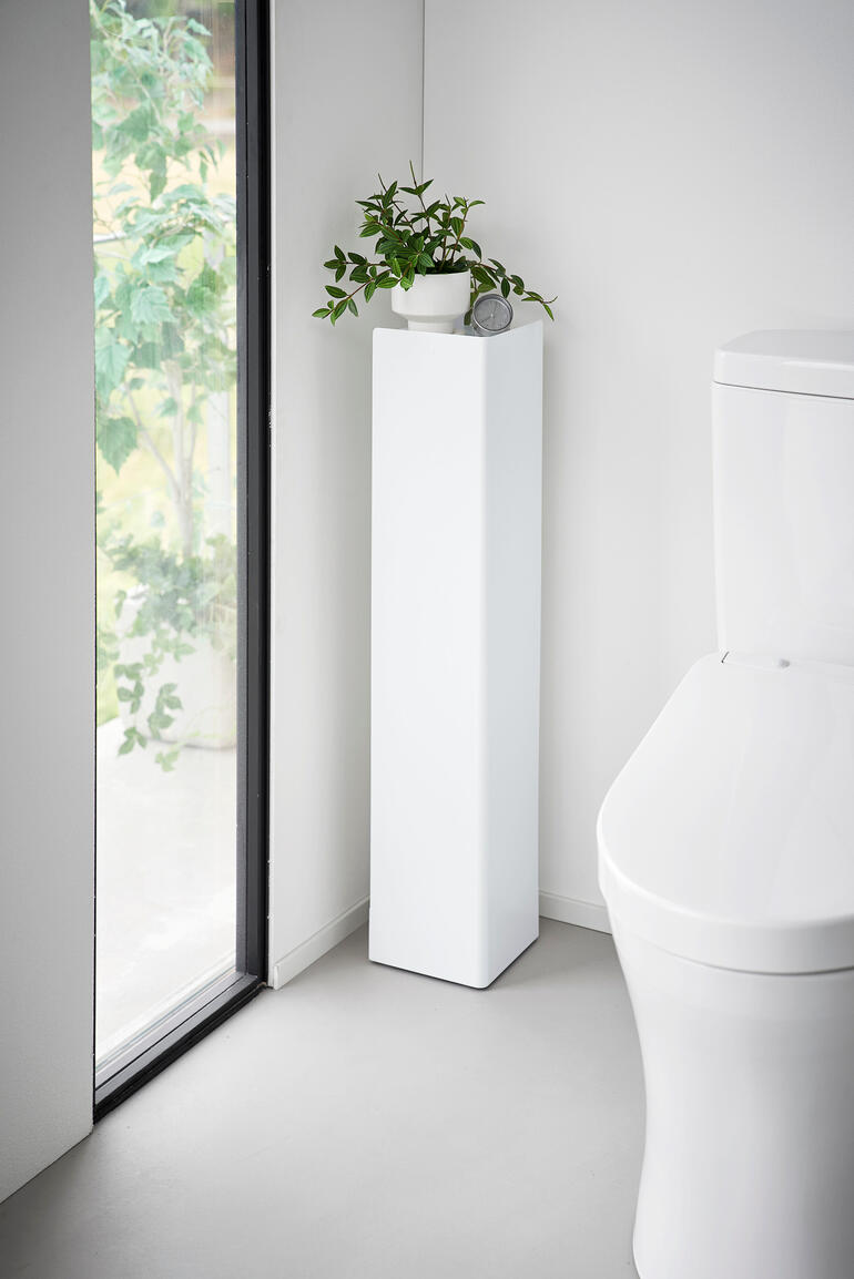 Witte WC-organizer met plant en decoratie in de hoek