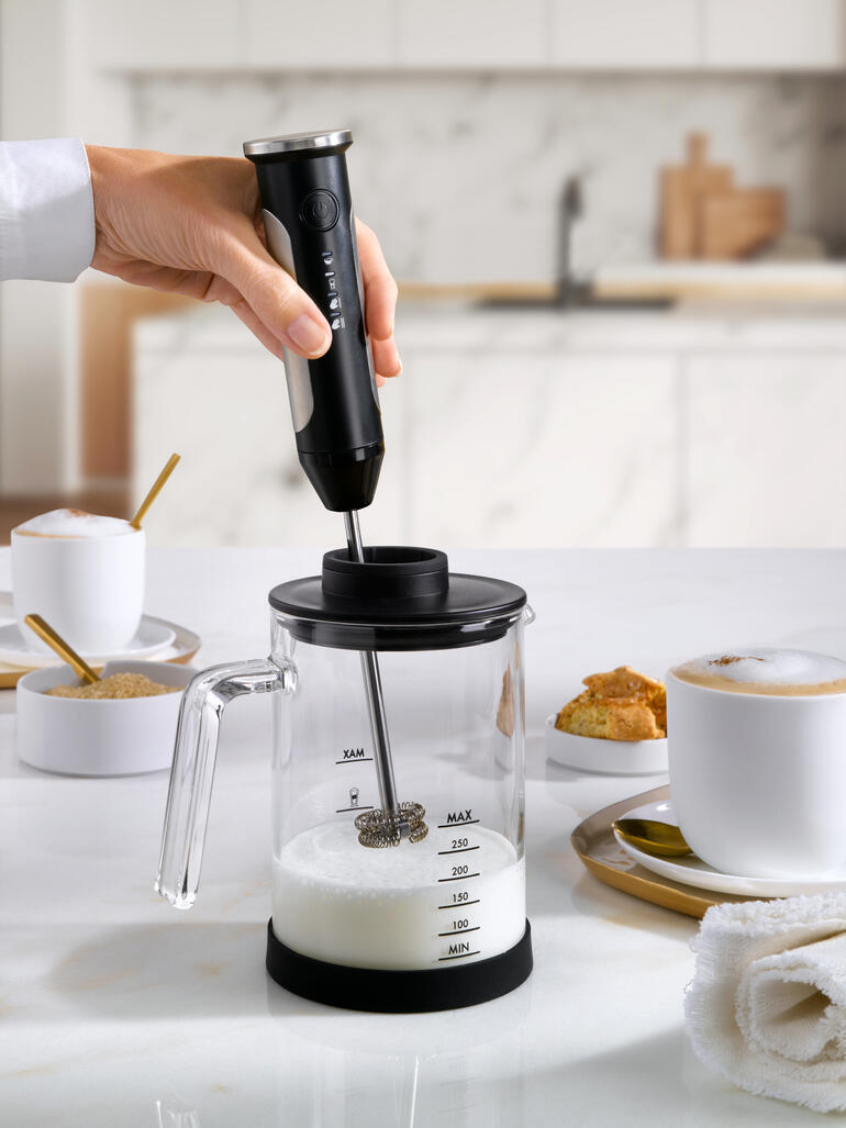 Accu melkopschuimer die met melk wordt gebruikt