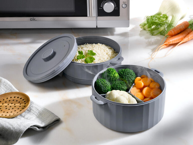 Dubbele stoomkoker met groenten en rijst in een grijze kom.