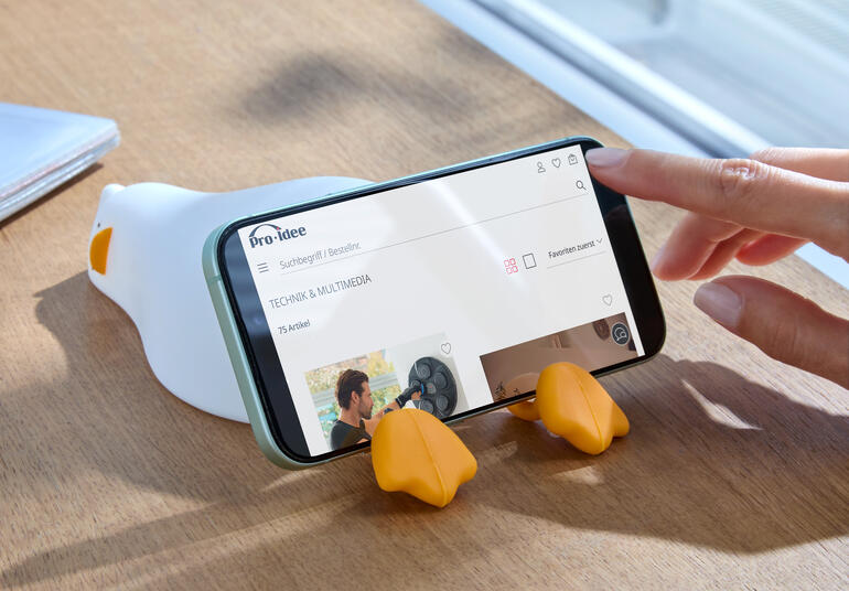 Moeie eend nachtlicht, op een tafel naast een smartphone.