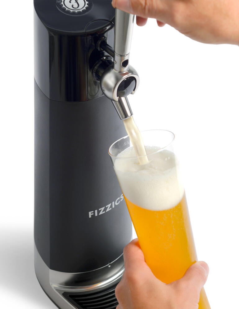 Handen tappen bier uit de bier-tapinstallatie in een glas.
