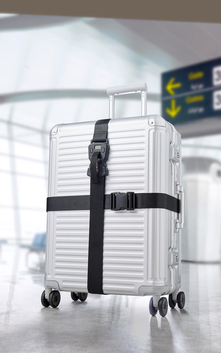 Zilveren koffer met zwart premium bagagestraps set 3-in-1 op een luchthaven.