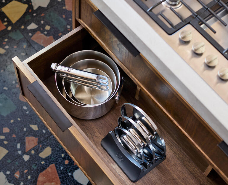 Kookset met opvouwbare handvatten in een keukenschuif, zichtbare pannen en deksels.