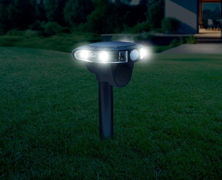 Elektronische dierenbestrijding 's nachts, verlicht met twee witte lampen.