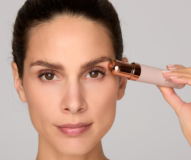 Vrouw houdt gezichtsrasierer Roxy tegen haar wenkbrauw.