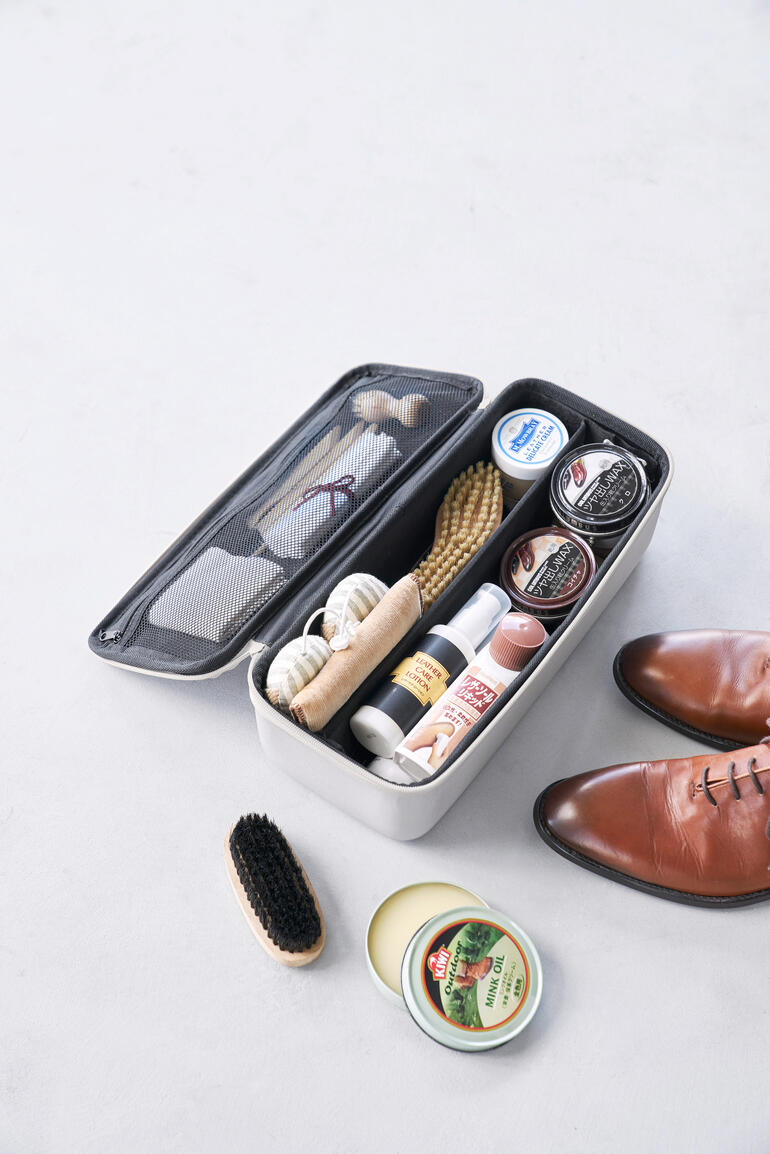 Lichtgrijze gereedschapsdoos met inhoud op een neutrale achtergrond.