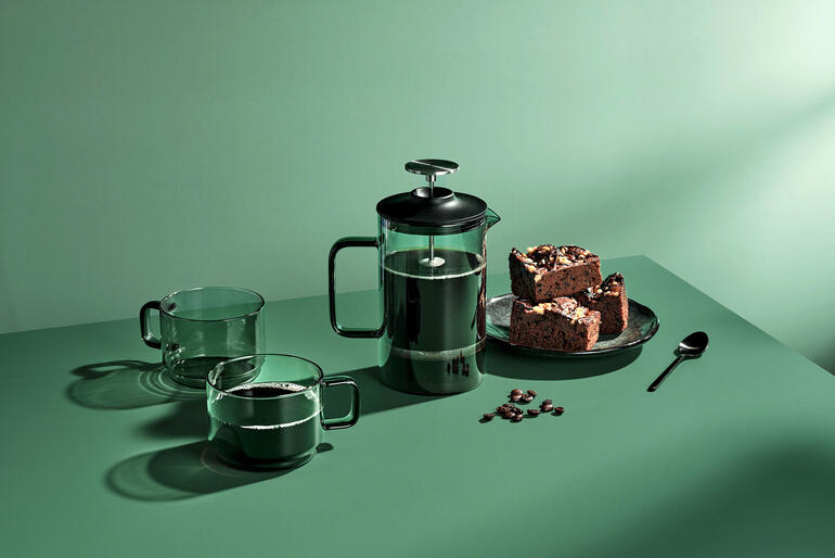 Mondgeblazen French-Press van 600 ml met chocoladekoekjes en glazen op een groene tafel.