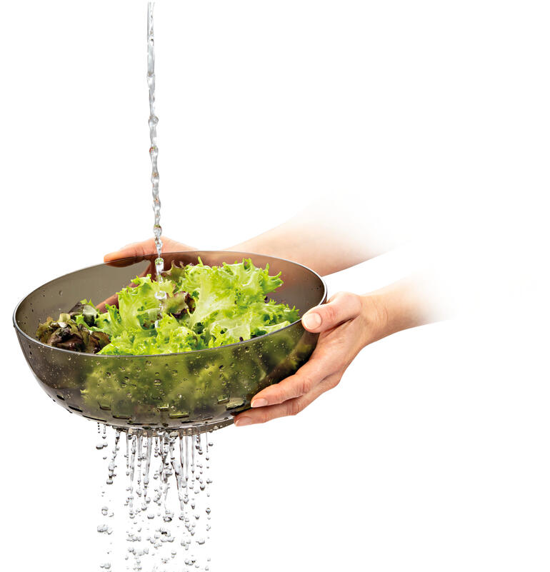Groene sla wordt gewassen onder water in een 3-in-1 schaal