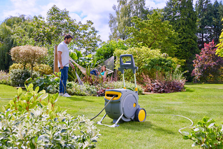 Man giet water met een slang uit een gesloten slangwagen
