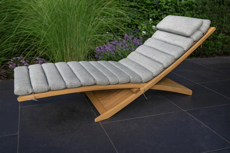 Premium houten ligstoel met grijze kussen in de tuin.