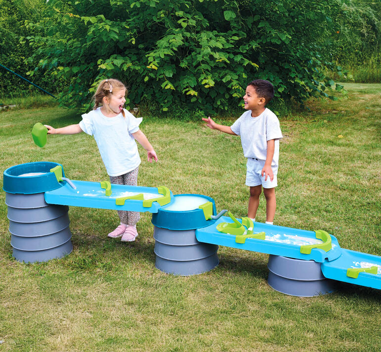 Twee kinderen lachen en spelen bij de water- en modderbaan.