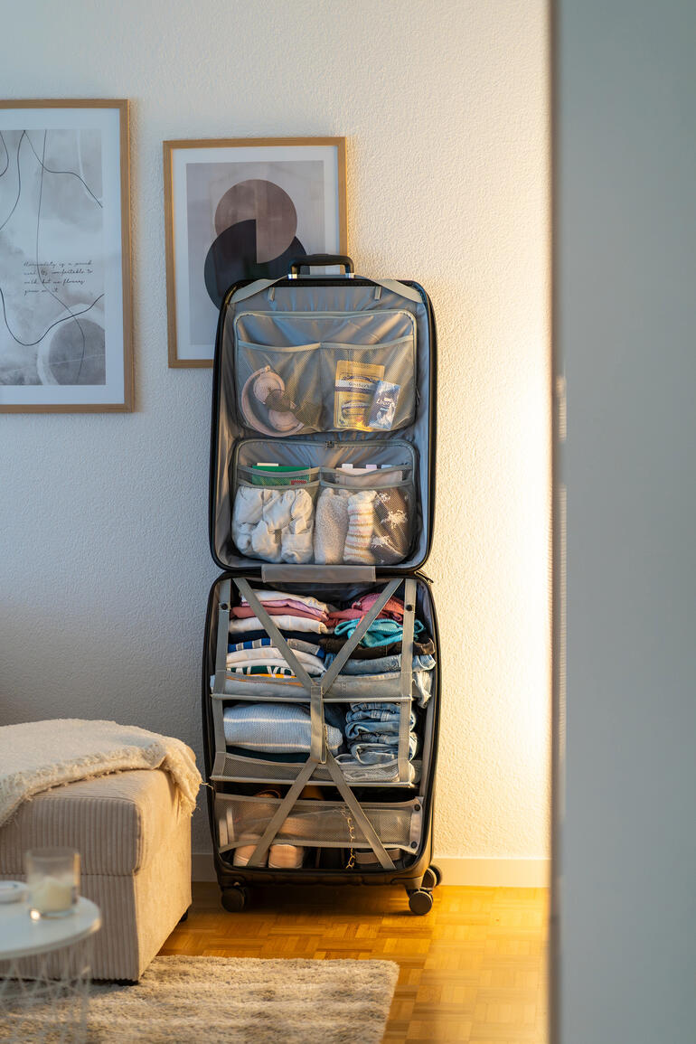 Kledingkoffer in de kamer, netjes gevuld met kleding.