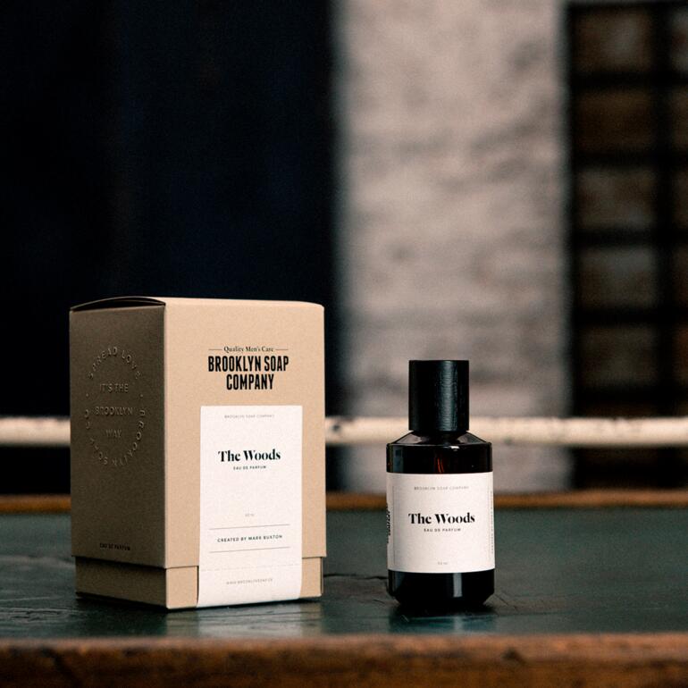 Eau de parfum ‘The Woods’, 50 ml The Woods Eau de Parfum met verpakking op een tafel