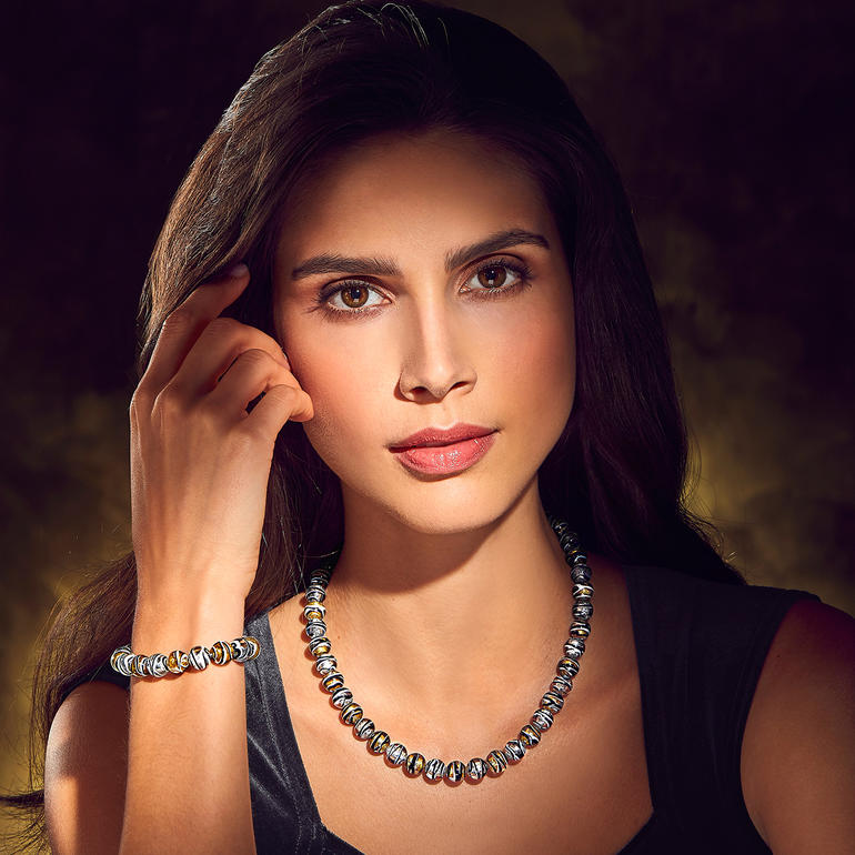 Murano-kralenarmband en -collier op de pols en hals van een vrouw.