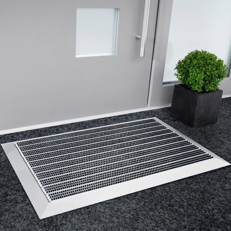 Aluminium entree mat voor een deur binnen neergelegd.