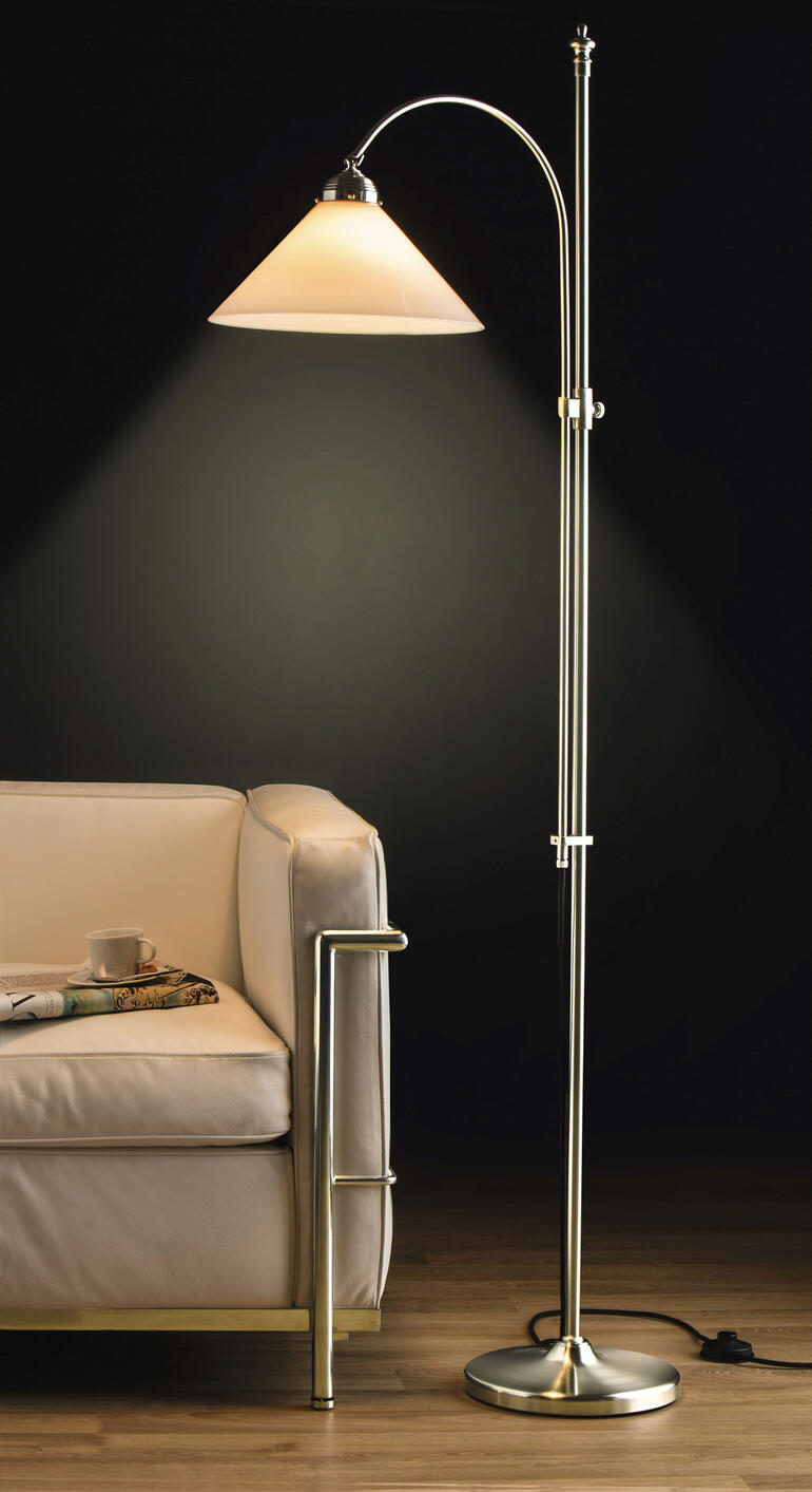 Berliner messing vloerlamp met lampenkap op een houten vloer naast een bank