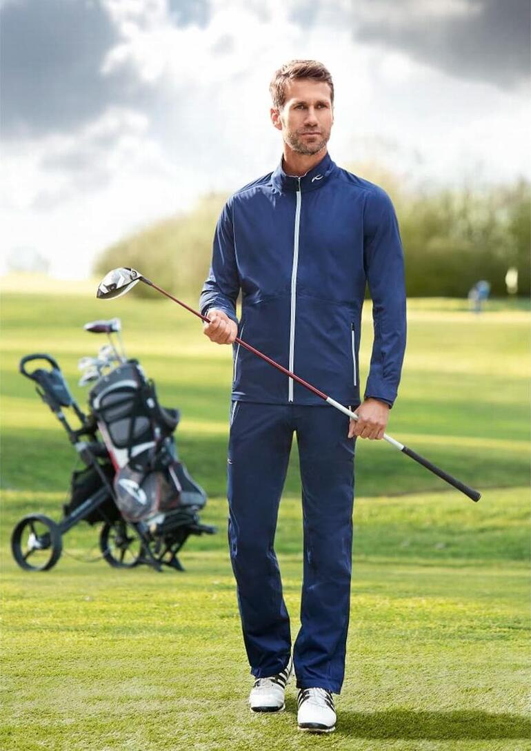 Man in KJUS functionele kleding staat op de golfbaan.