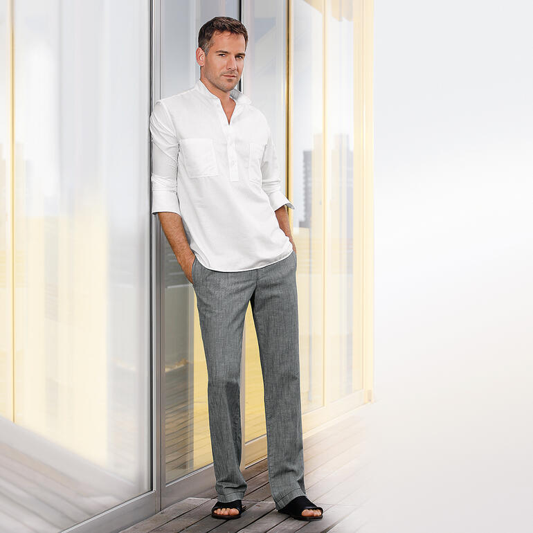 Hollington Nehru-katoenoverhemd Man in Pantalon confort à cordon coulissant staat tegen de muur