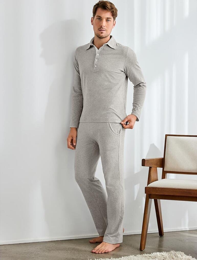 Loungewear-pak, grijs-gemêleerd Man in grijze melange loungewear-pak staat in de kamer
